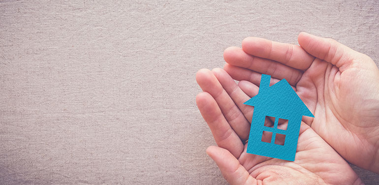 Cut out of blue house in hands