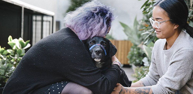 Two of the 1,500 trainees who have been supported by hospitality social enterprise STREAT, with therapy dog Magic. Photo: Alana Holmberg.