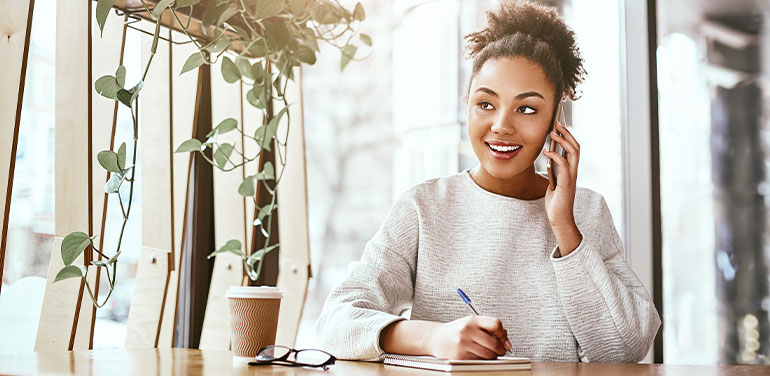 Woman sitting in a cafe speaking on the phone.