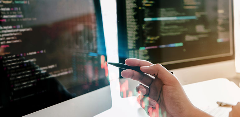 close up of a hand pointing at a computer screen