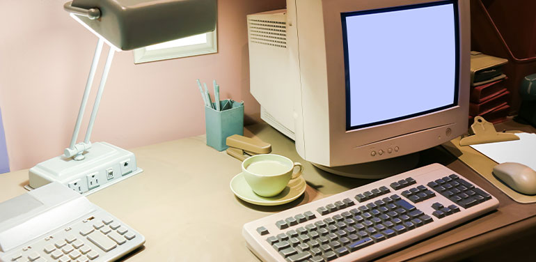 A desk from the 1990s with phone and PC