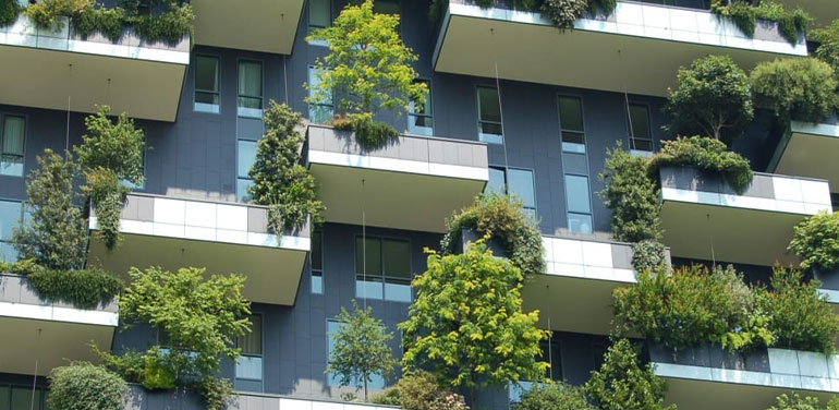 high rise with green trees planted on each balcony.