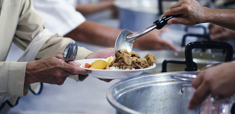 people serving in a food kitchen.