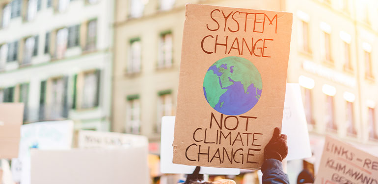 protest sign saying system change not climate change