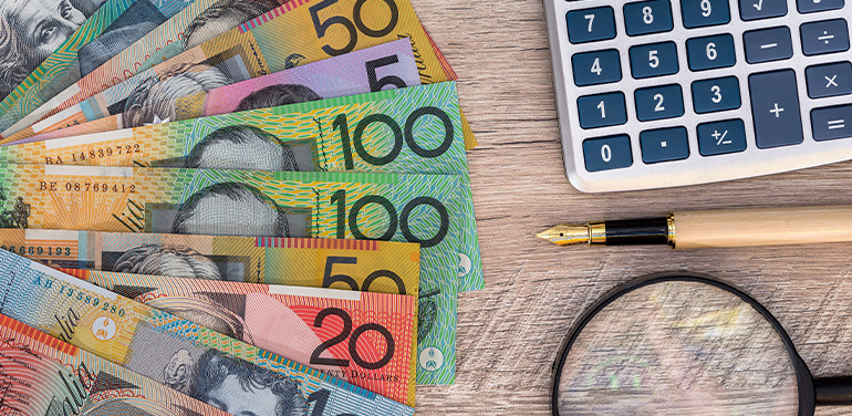 Australian dollars with calculator, pen and magnifier