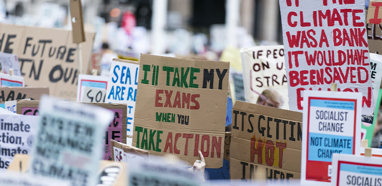 People with banners protest as part of a climate change march