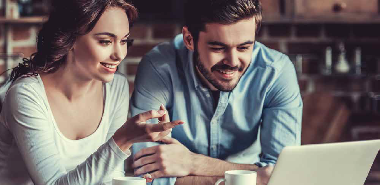 A man and woman looking at a laptop