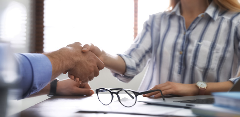 people shaking hands across a desk