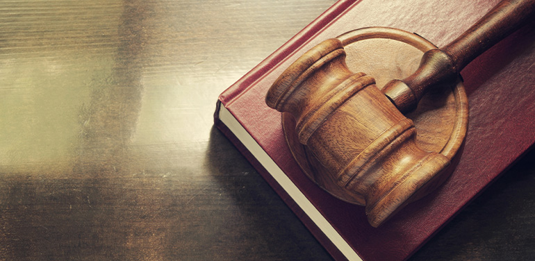 Gavel and legal book on wooden table