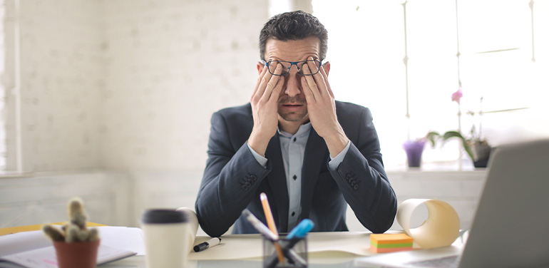 man looking stressed at desk