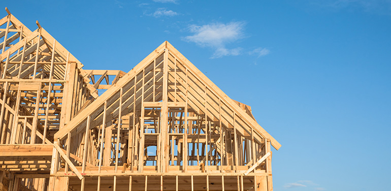 Close-up of gables roof on stick built home under construction and blue sky