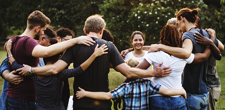 group of people huddle together in the park