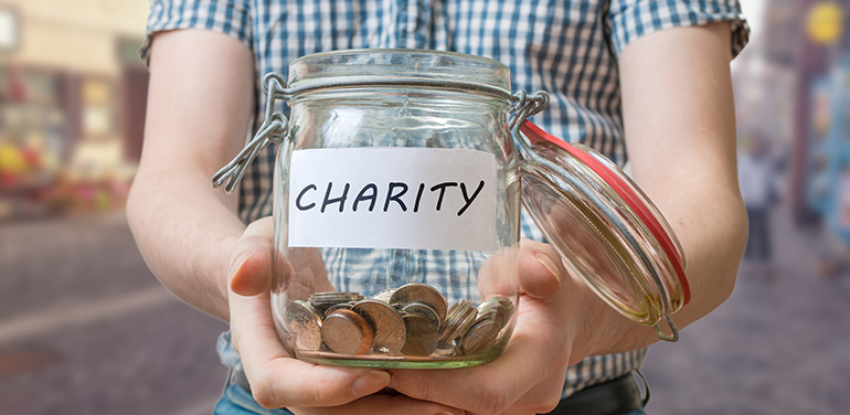 person holding jar that says charity on it