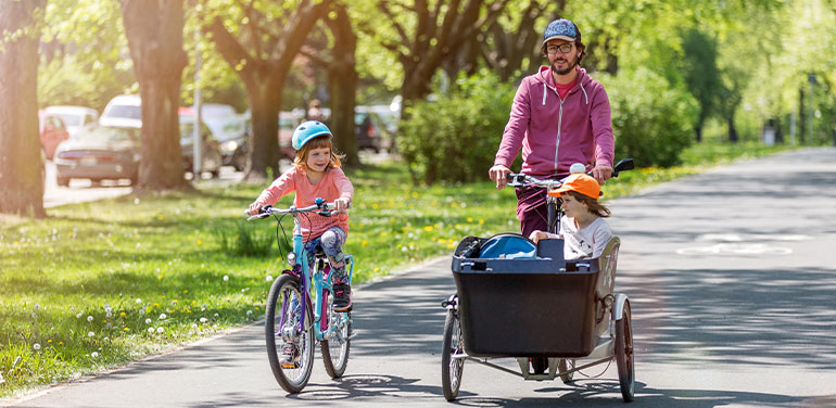 Father and daughters having a ride with cargo bike