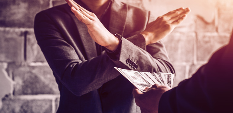 man putting his arms in a cross to reject money being offered by another man