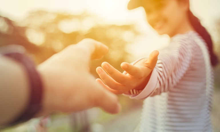 Teen smiling as someone reaches for her hand