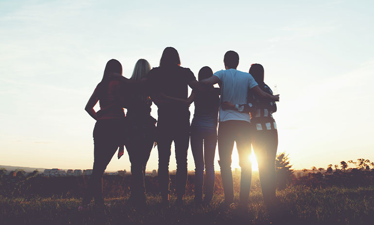 group of friends looking into the sunset