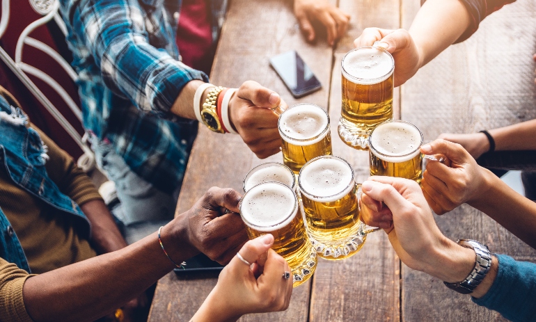 Group of people enjoying and toasting a beer in brewery pub