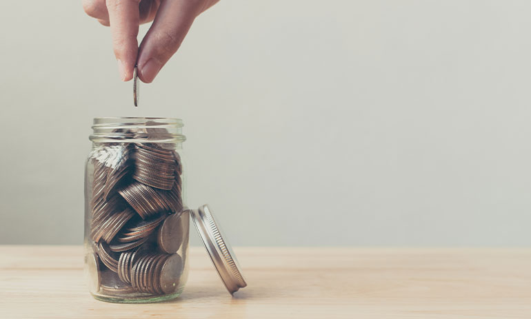 person putting a coin in a jar