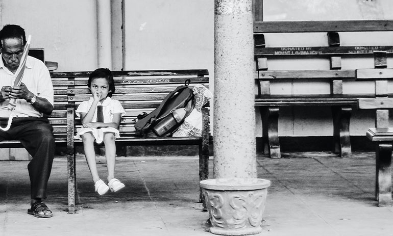 Father and daughter sitting on a bench