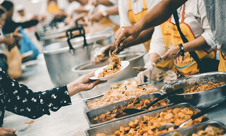 people serving food in a soup kitchen