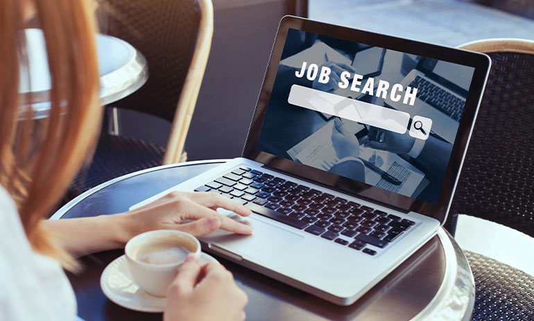 woman in a cafe looking for a job on her laptop