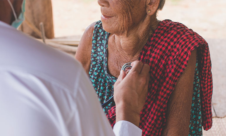 doctor treating migrant woman in refugee camp in Myanmar.