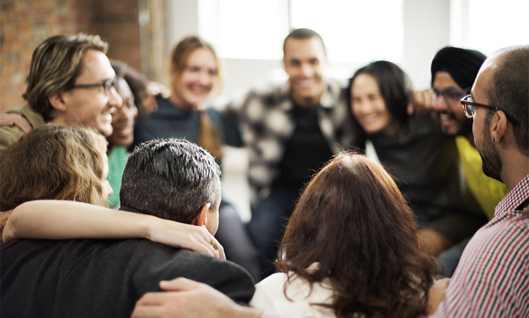 group of people in a circle with their arms around each other