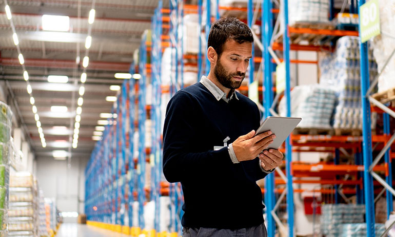 manager of a warehouse looking at a digital tablet.