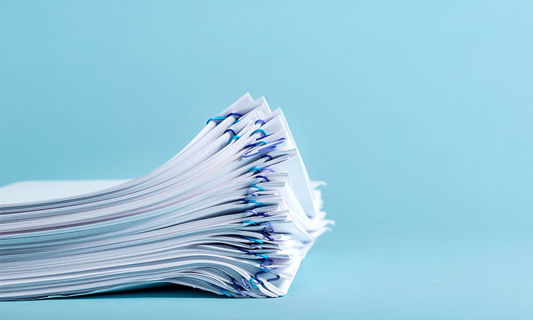 stack of paperwork on a blue background