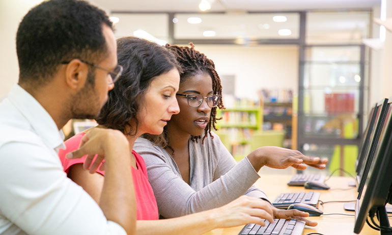 three young people on computer