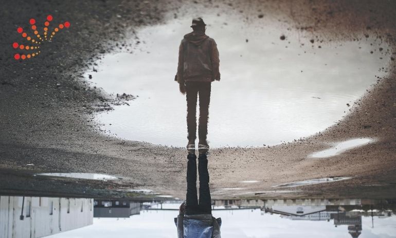 reflection in a puddle of man walking