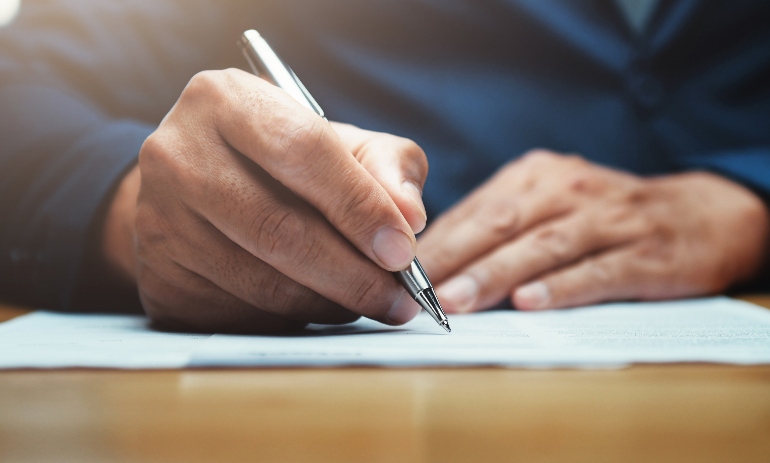 businessman writing on paper report in office