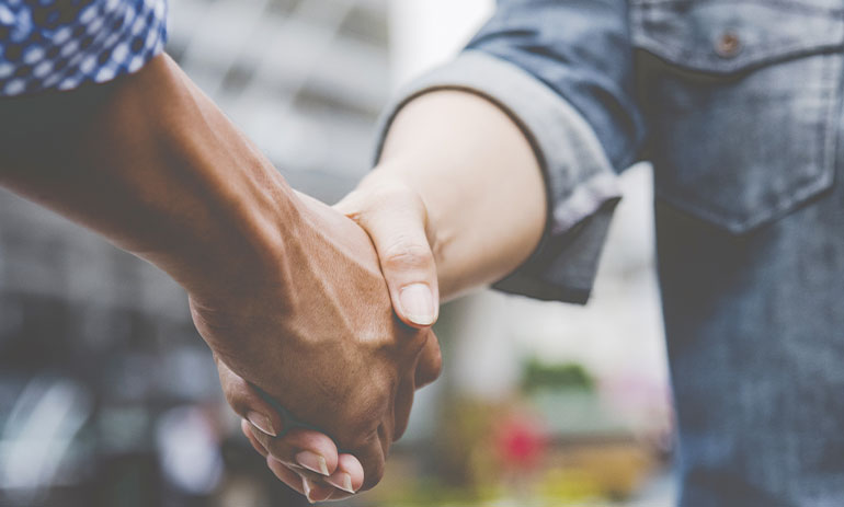 close up two people shaking hands