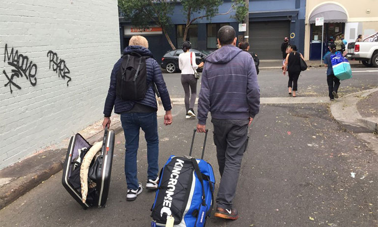 people carrying suitcases into a hotel