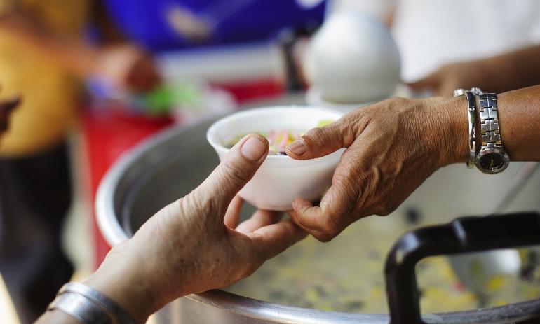 Charity worker hands food to a person