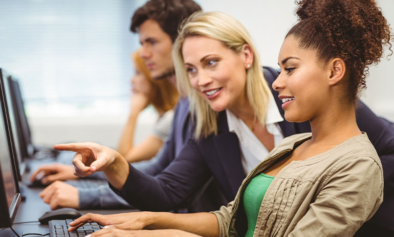 woman teaching people how to use computer