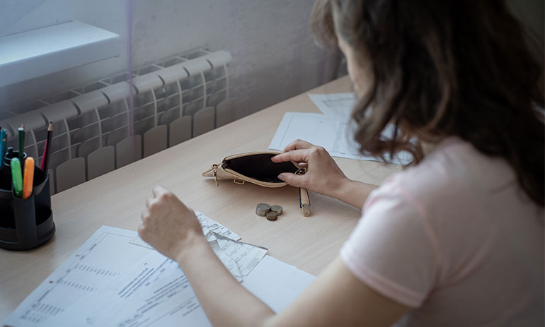 Woman counting coins looking at bills