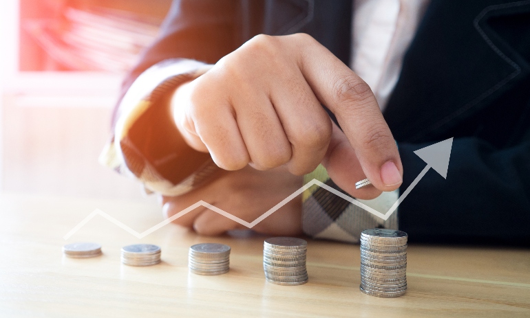 Woman putting coins on stack with holding money