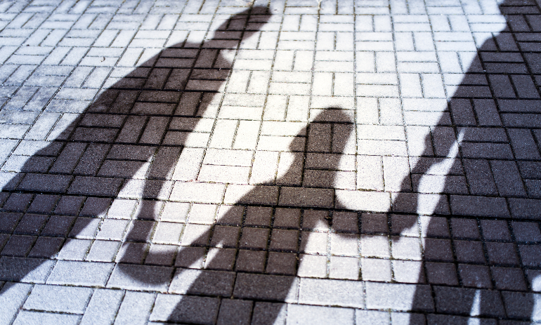 Parents holding child's hands shadow