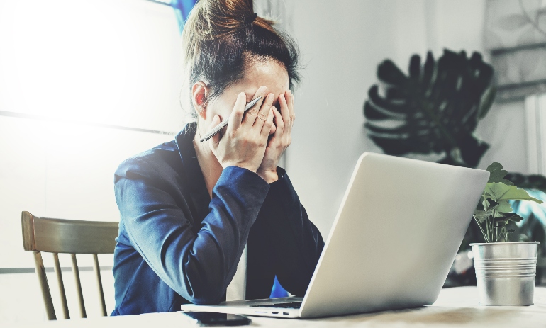 Young woman stressed sitting at laptop