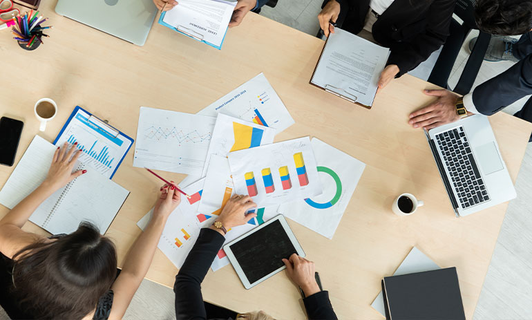 aerial view of a table with paperwork and people sitting around