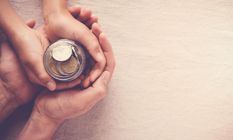 hands holding a jar of coins