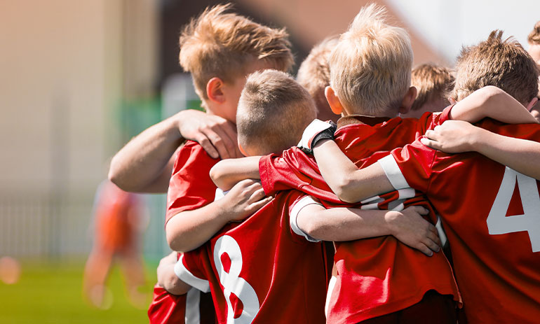 kids soccer team hugging