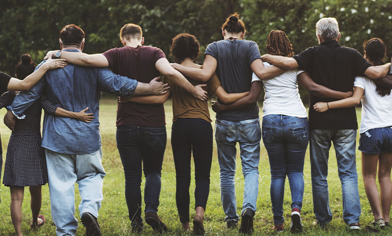 group of people walking with arms around each other