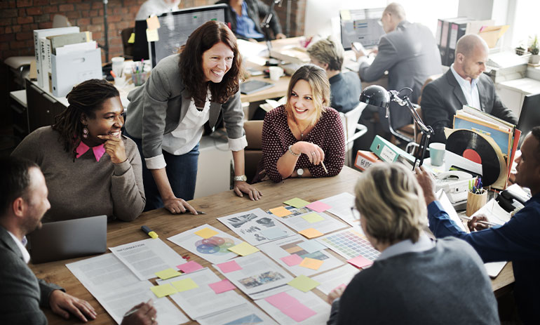 people working together at a table with paper work on it