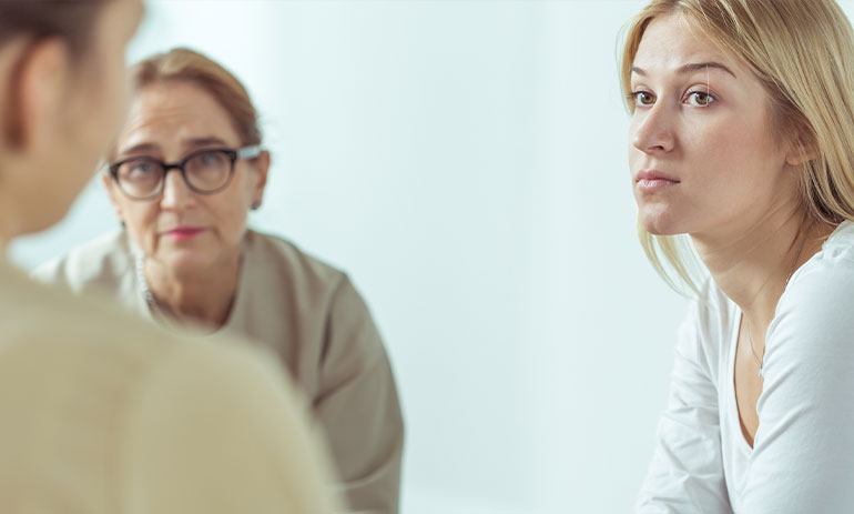 three people sitting talking looking serious