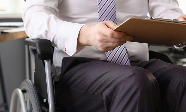 man in wheelchair holding a clipboard