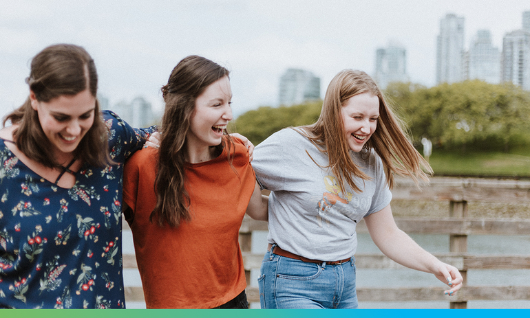 Three women walking together, smiling