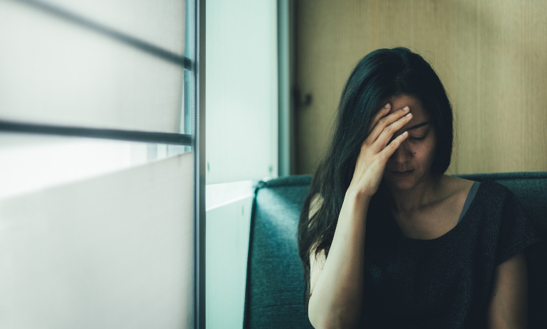 Distressed person with head in hands